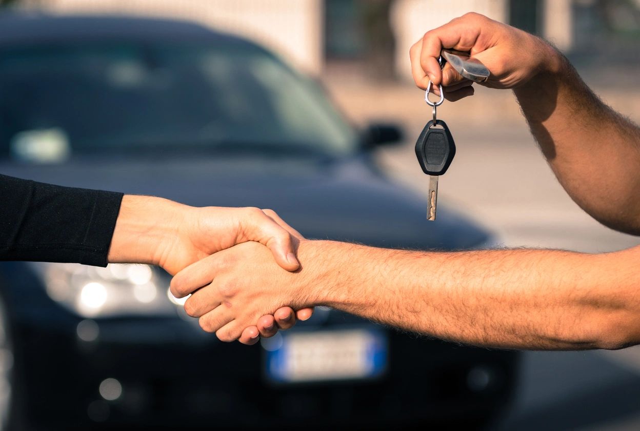 Woman handing car shipping man the keys to her car